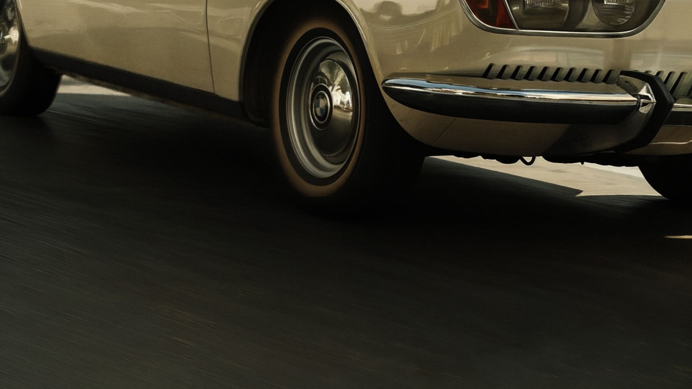 A vintage cream car speeding along a road
