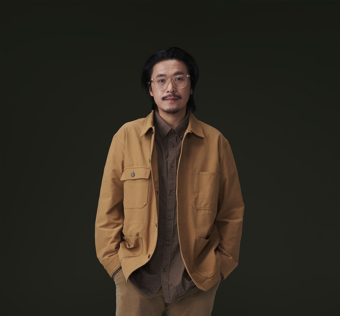 Portrait of Baz Poonpiriya in a tan work jacket