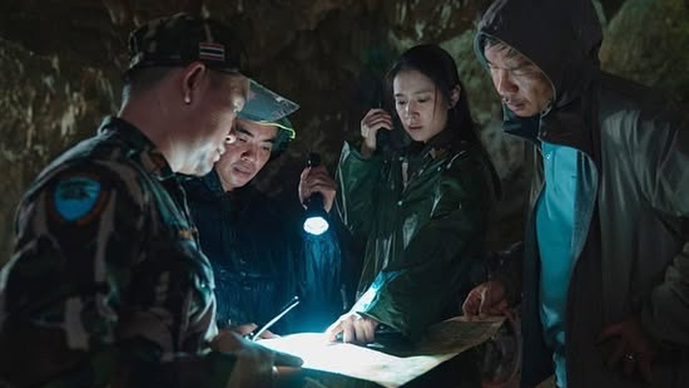 The rescue team studying a map by torchlight